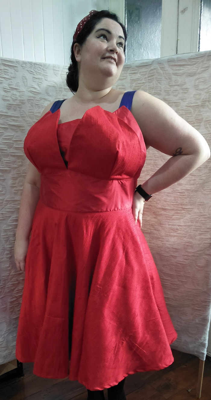 Beautiful woman in a red silk dress custom made by Velvet Cherry, New Zealand, with a tulip petal bodice.